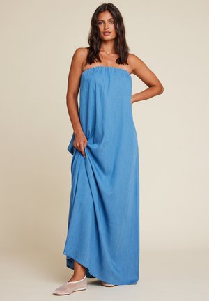 Blå denim maxi-kjole med strapless design, samlet halslinje, flytende silhuett og myk tekstur. Brukt med lyse leiligheter.