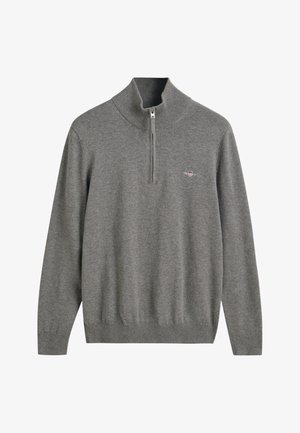 Szary dzianinowy pulower z wysokim kołnierzem i zamkiem błyskawicznym na ćwierć długości. Posiada ściągacze na rękawach oraz u dołu, a także małe wyszywane logo na piersi.