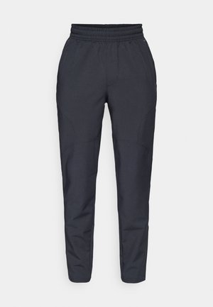 Marineblauwe tapered broek van zachte stof, voorzien van een elastische tailleband, zijzakken en een gladde textuur met subtiele stikseldetails.