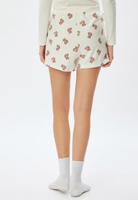 Hvide shorts med et legende teddy bear-print i brun. Blødt materiale, afslappet pasform og en elastisk talje til komfort.