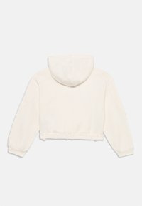 Gekürzter weißer Hoodie aus weichem Stoff mit Kapuze, langen Ärmeln und einem Bindedetail an der Taille. Glatte Textur, minimales Design.