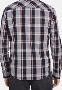 Chemise pour homme à manches longues à carreaux, présentant un mélange de couleurs marine, blanc et orange, avec un poignet boutonné et un motif à carreaux distinct au dos.