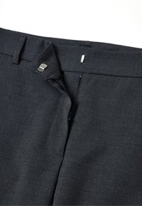 Donkergrijze broek met een gladde textuur, een traditionele rits en een zilveren hardwareaccent bij de taille.