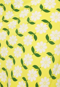 Tecido amarelo com um padrão repetido de flores brancas com folhas verdes. O design é vibrante e divertido, enfatizando elementos florais.