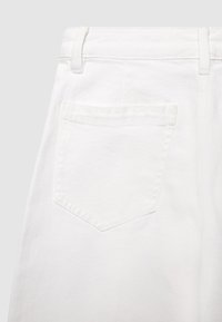 Pantaloni in denim bianco con una tasca posteriore a forma di diamante, dettagli cuciti e una texture liscia. Passanti per cintura visibili in vita.
