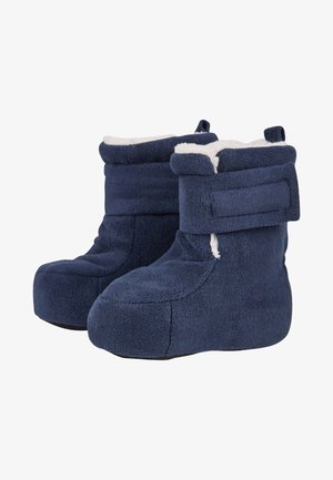 Pair of navy blue fleece boot slippers with white plush lining and adjustable Velcro straps on a white background.
