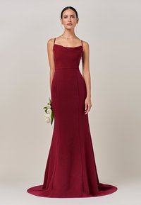 Bordo večernja haljina s pripijenim korzetom, tankim naramenicama i širokom suknjom. Glatka tekstura, do poda s blagim repom.