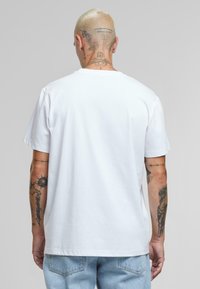 Witte katoenen t-shirt met korte mouwen, ronde halslijn en een ontspannen pasvorm. Heeft een gladde textuur en een eenvoudig ontwerp.