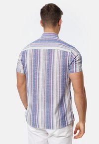 Short-sleeve shirt with vertical blue, white, and red stripes. Lightweight fabric with a textured finish and a point collar. Back yoke detail.