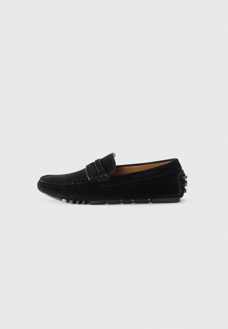 Black suede loafers with a smooth finish, featuring a decorative strap and rubberized sole for traction. Classic and minimalist design.