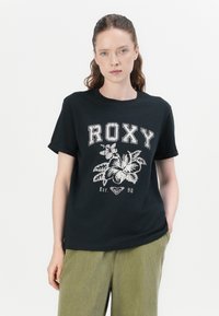 Black cotton t-shirt featuring "ROXY" text, floral graphic design, and established year "Est. 90" in a contrasting light color. Short sleeves.