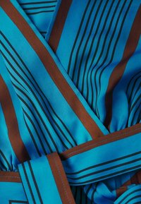 Tela azul con rayas verticales en marrón y negro, que presenta una textura suave y un detalle de cintura anudada.