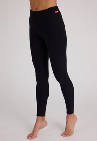 Zwarte leggings met een gladde textuur, een hoge elastische tailleband en minimale stiksels. Beschikt over een klein rood logo-label op de tailleband.