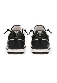 Schwarze Sportschuhe mit einer strukturierten Oberseite, weißen Akzenten und einer Gummisohle. Mit Zuglaschen und Logodetails an der Ferse.