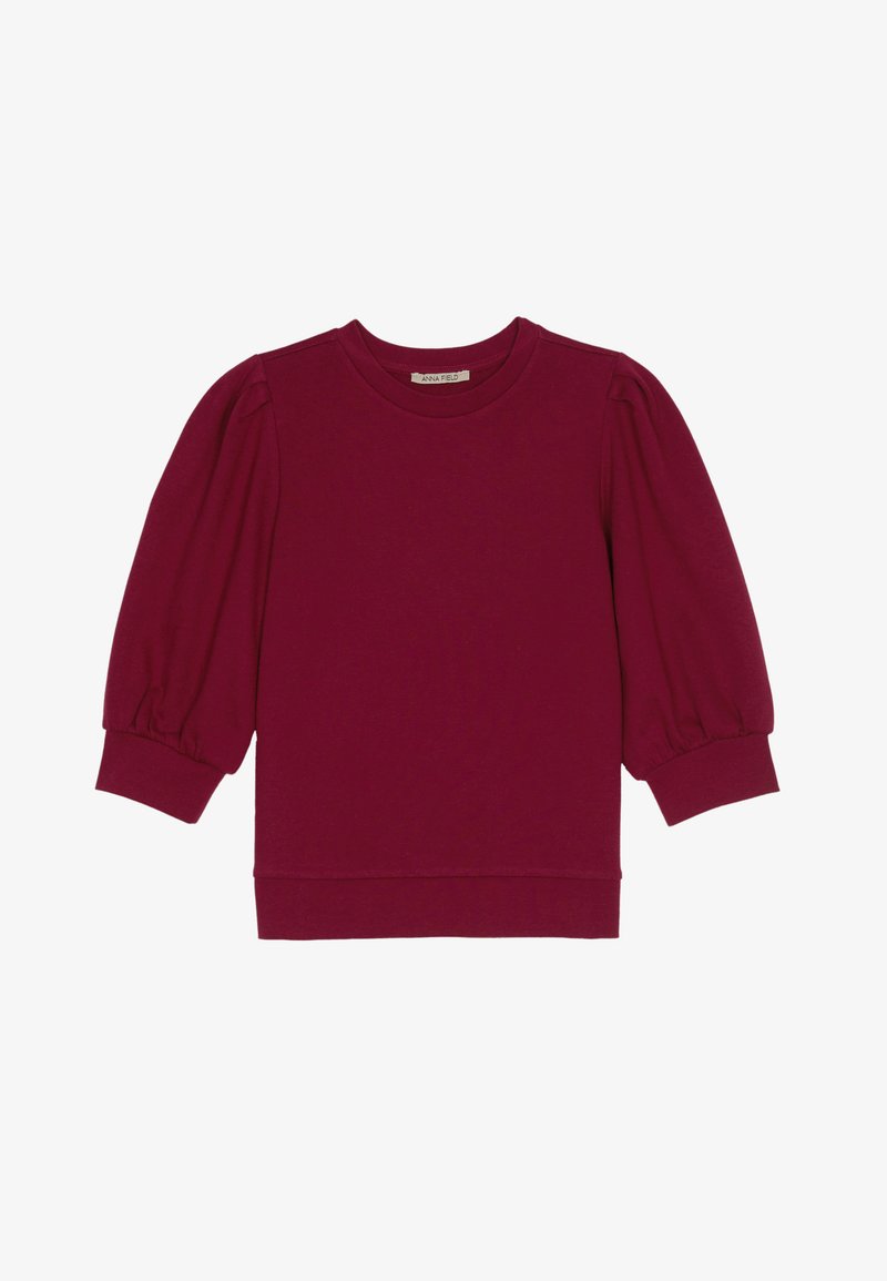 Bordo majica dugih rukava od pamuka, s okruglim izrezom i napučenim rukavima s uskim manžetama te opuštenim krojem kroz cijelo tijelo.