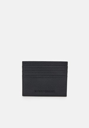 Črn usnjen etui za kartice z teksturirano površino, ki ima štiri prostore za kartice in embosirano blagovno znamko na dnu. Kompaktna in pravokotna zasnova.