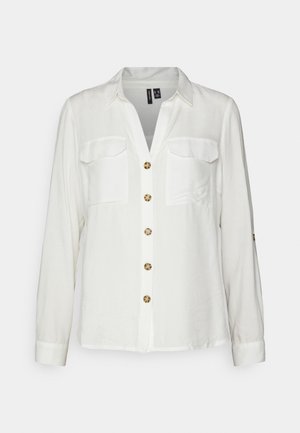 White long-sleeve blouse with two chest pockets, button-down front featuring round beige buttons, and structured collar. Smooth fabric texture.