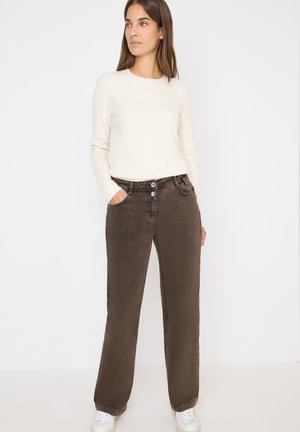 Brune brede bukser med to knapper, sidelommer og en blød tekstur. Kombineret med en cremet sweater og hvide sneakers.