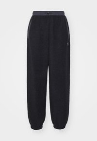 Fleece joggingbroek in effen zwart met een elastische tailleband, koord en zijzakken. Gesmokt aan de enkels en van zacht, textuurstof.