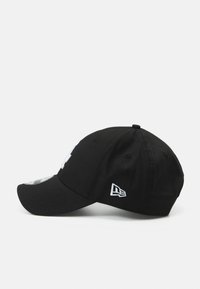 Schwarze Baseballkappe mit gebogenem Schirm. Verfügt über ein gesticktes Logo in Weiß auf der Vorderseite und das "New Era"-Logo an der Seite. Aus Baumwollstoff.