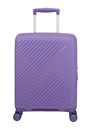 Valigia rigida viola con scanalature diagonali, manico telescopico, quattro ruote girevoli e logo American Tourister sulla parte anteriore.