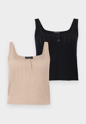 Δύο αμάνικα ριμπ πλεκτά τοπ, ένα μπεζ και ένα μαύρο, το καθένα με δύο κουμπιά κοντά στον τετράγωνο λαιμόκοψη.