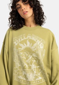 Overmaatse olijfgroene sweatshirt gemaakt van katoen, met een witte grafische ontwerp met bergen, cactussen en bloemelementen.