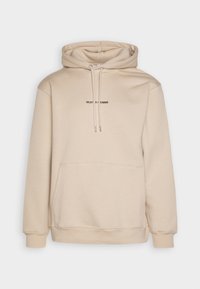 Felpa beige con cappuccio regolabile, tasca a marsupio frontale e discreto testo del logo nero. Il tessuto è morbido, liscio e leggermente elastico.