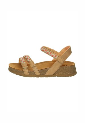 Beige sandal with cork sole, three straps including two braided cream and red straps across toes, and one adjustable strap around ankle.
