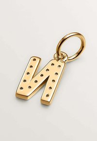 Llave con forma de la letra "N" en metal dorado, con detalles perforados, unida a un anillo circular. Superficie suave con un acabado pulido.