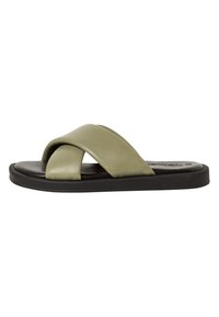 Sandale à glissière en cuir vert avec des brides croisées, semelle noire, design plat, texture lisse et apparence minimaliste.