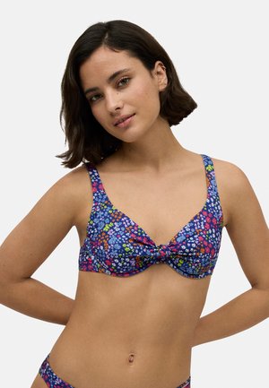 Bañador floral con fondo azul marino; presenta colores vibrantes, detalle de lazo en el centro y tirantes anchos para mayor soporte.