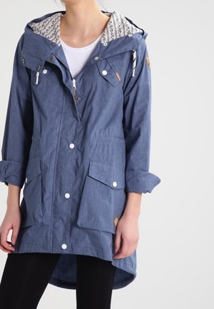 Veste bleue à capuche en tissu texturé, avec des boutons, deux poches avant et une doublure intérieure à motifs. Coupe longue et décontractée.