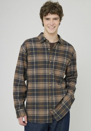 Chemise en flanelle à carreaux marron et bleu marine avec fermeture à boutons, col et manches longues. Tissu texturé avec une coupe décontractée, légère brillance.