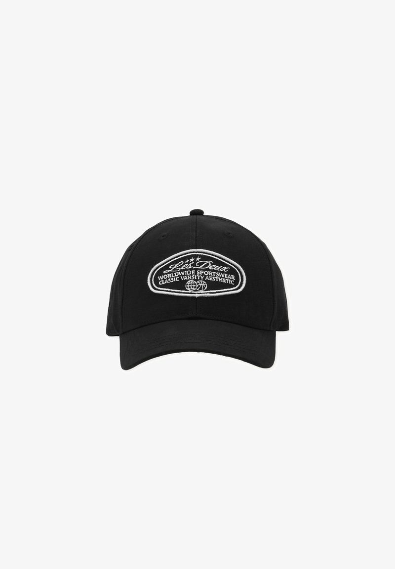 Casquette de baseball noire avec une visière incurvée et un patch blanc brodé indiquant "Les Deux Worldwide Sportswear Classic Varsity Aesthetic."
