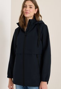 Veste imperméable bleu marine avec fermeture éclair �à l'avant, capuche ajustable, poches latérales et poignets élastiques. Design élégant et léger avec des accents minimalistes.