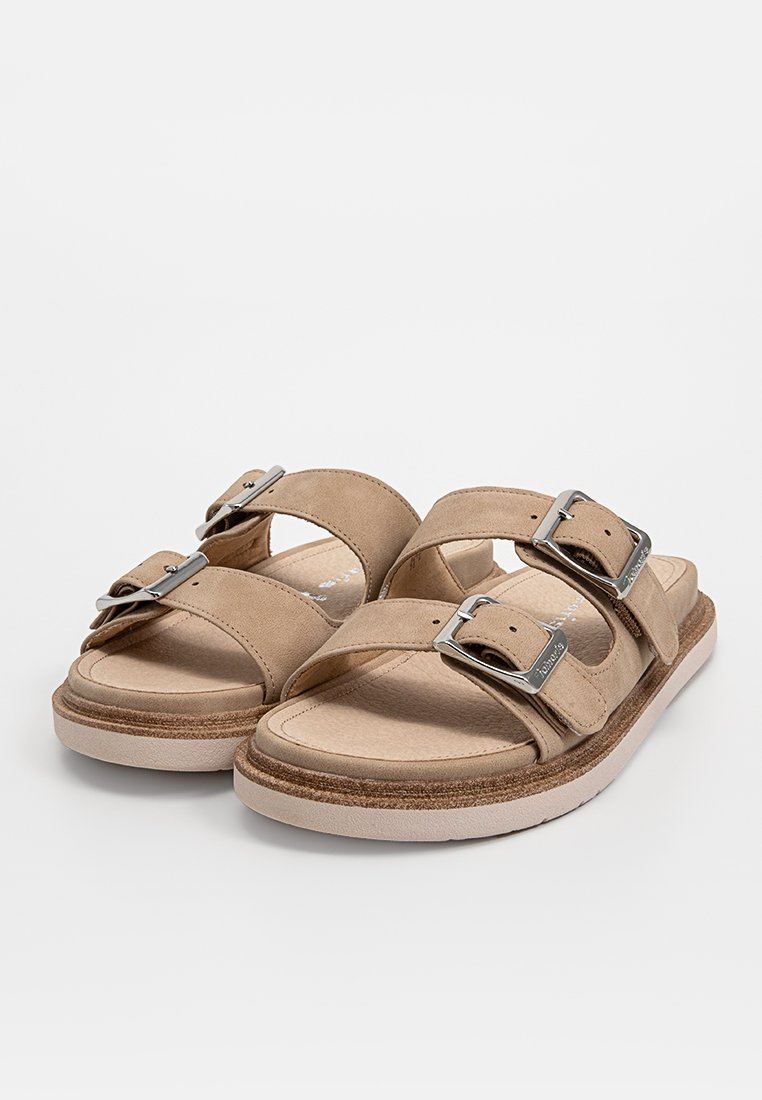 Beige Sandalen mit zwei breiten Riemen und silbernen Schnallen. Weiches, wildlederähnliches Material, gepolsterte Innensohle und eine strukturierte Außensohle.