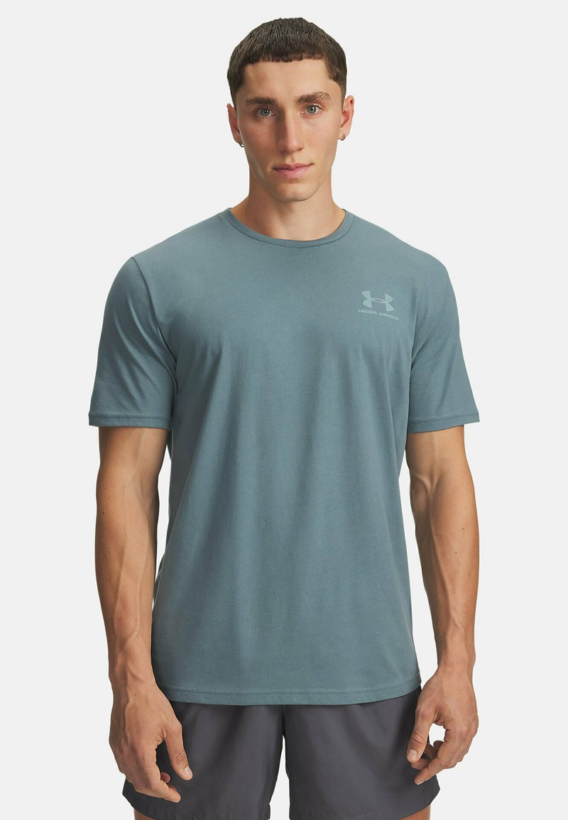 Šviesiai mėlynas sportinis marškinėlis, pagamintas iš minkšto medvilnės mišinio, su trumpomis rankovėmis ir apvaliu kaklu. Maža logo ant krūtinės.