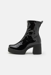 Botine negre din piele lacuită, cu toc bloc înalt, închidere cu fermoar și textură netedă. Dispune de un toc plat pentru stabilitate.