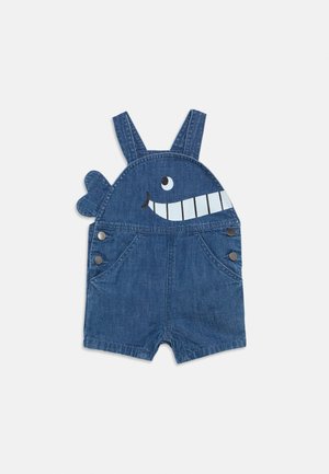 Denim-Latzhose für Kleinkinder mit einem lächelnden Walgesicht und Schwanzflossen-Detail auf dem Latz, mit verstellbaren Schulterriemen und seitlichen Knopfverschlüssen.