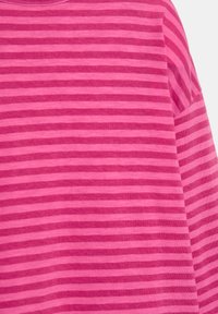 Rosa stribet stof med skiftende lyse og mørke nuancer, med en blød tekstur og en rund hals.