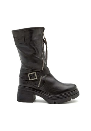 Bottine en cuir noir avec un talon épais, fermeture éclair latérale et sangle ajustable avec boucle métallique. Texture lisse et design à bout rond.
