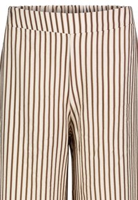 Weiße Stoffhose mit schmalen, vertikalen braunen Streifen; elastischer Bund; weiche Textur; lässiges Design.