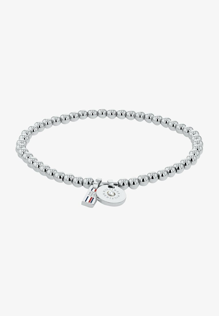 Bracelet en perles argentées avec deux petits charms, un rond gravé de texte et un rectangulaire aux couleurs rayées.