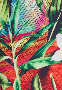 Tela con patrón que presenta verdes y rojos vibrantes con un diseño floral. Contiene hojas texturizadas sobre un fondo degradado.