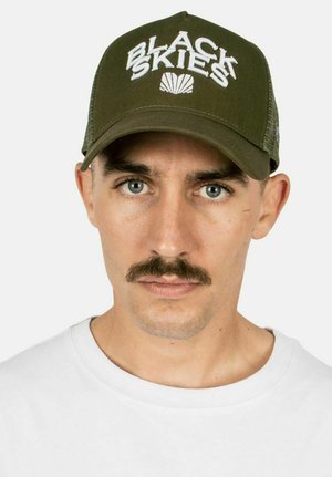 Olive green baseball cap with "BLACK SKIES" embroidered in white, featuring a mesh back and a curved brim. Textured finish with bold lettering.