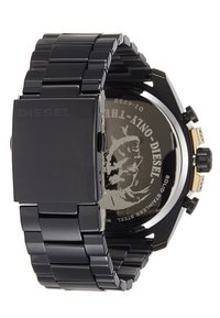 Montre en acier inoxydable noir avec un design de bracelet chunky, dotée d'un boîtier carré et d'un cadran noir avec logo en relief et accents métalliques.