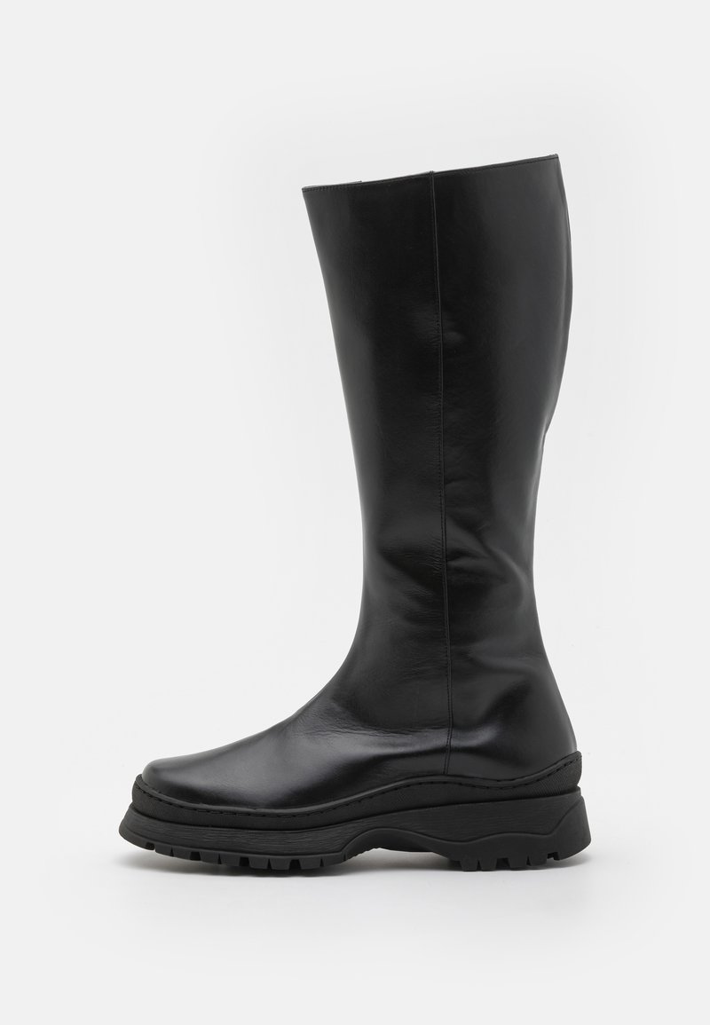 Čierne kožené čižmy po kolená s hladkým povrchom, zaoblenou špičkou a hrubou gumovou podrážkou s textúrovaným vzorom.
