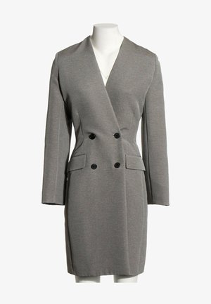 Vestido blazer gris de doble botonadura con mangas largas, botones negros y dos bolsillos con solapa delante, sobre un maniquí blanco.