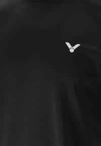 Svart bomullströja med rundad halsringning och korta ärmar. Har en liten vit logotyp på vänster bröst. Slät textur.